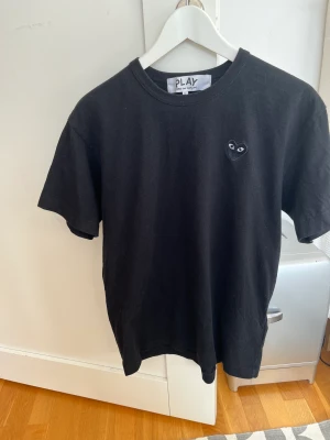 CdG Play black heart t-shirt  - Säljer nu min svarta tröja från cdgplay fick i november 2022 men hade knappt någon användning för den. Köptes på NK på Paul and freinds. 100% Bomull. Och är som Ny. 
