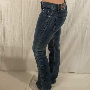 Lågmidjade jeans med coola detaljer vid benen med midjemått: 76cm och innerbenslängd: 79cm