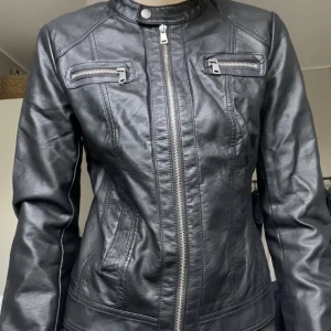 Skinjacka - Svart jacka i läderimitation. Storlek 38. För storleksreferens bär jag oftast S. 