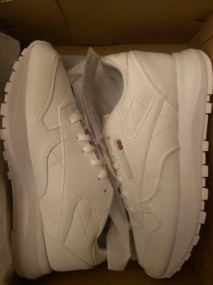 Rebook sneakers  - Jag säljer dom här Reebok sneakers i storlek 40,5. Jag beställde dom och dom kom för små för mig, det är setförlust jag säljer dom. Dom är helt oandvända och dom har forfarande kartong delen på som ni ser i bild 2.