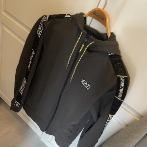 EA7 Zip Hoodie - Tjena Säljer min riktigt Snygga EA7 Hoodie som är från en av deras nyaste kollektioner! Den är helt nyköpt och använd endast en gång! Köpte för 1400 så jag skulle vilja ha 750kr för den! Bara att höra av sig vid frågor