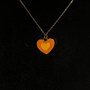 Halsband med hjärta i orange - Halsband i rostfritt stål. Guldpläterad samt emaljerad berlock. Fri frakt✨
