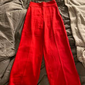 Fina röda kostymbyxor från Zara. Dragkedja på sidan. Dom ska vara ankel-långa och vida i benen. Knappt använda. Tyvärr har dom blivit för små de är därför det inte är så bra bilder och därför jag säljer, storlek XS.