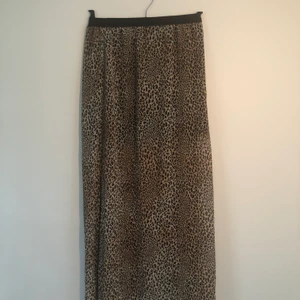 Kjol - Kjol i tunt genomskinligt tyg med slits på ena sidan. Kort svart underkjol. Material polyester