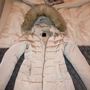 Glansig beige vinterjacka från Zara storlek M - Säljer min älskade dunjacka från Zara i storlek M som aldrig blir använd pga av att den är lite för tight för mig. Framhäver kurvorna, sitter snyggt! Den är i storlek M men liten i storlek. Stor fluffig päls. Köpt för 1600kr. Kan fraktas mot fraktkostnad.