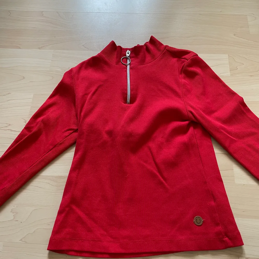 En röd tröja med dragkedja högst upp från kaphal i storlek 146-152. Väldigt fint skick och tvättas innan den skickas. !! Köparen står för frakten!!. Jeans & Byxor.