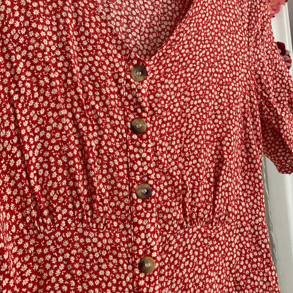 Jättefin rödblommig klänning från H&M i storlek 34. Väldigt fint skick med fina detaljer på ärmarna. Sitter superfint och är sval! 100 kr sista bilden visar hur den sitter på, den går till knäna på mig som är 160 lång!. Klänningar.