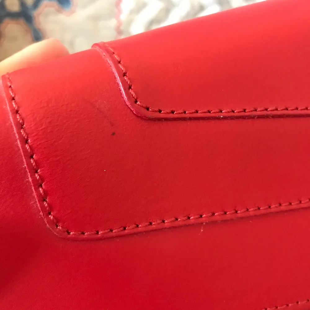 Never worn red leather bag with gold hardware. Bought from Italy. Has a small barely noticeable pen mark on the flap, please see the last photo. This could be easily covered by a pin or scarf. . Väskor.