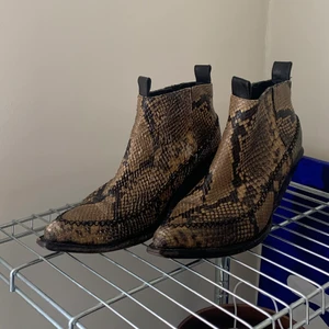 H&M trend boots i orm - Supersnygga boots i ormakinnsmönster. Materialet är läder och strl 39. En aning slitna, men snyggt. 