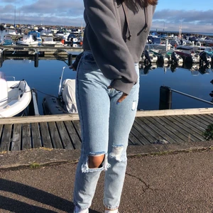 Ljusa jeans  - Högmidjade ljustvättade jeans med hål i knät. Stl 34