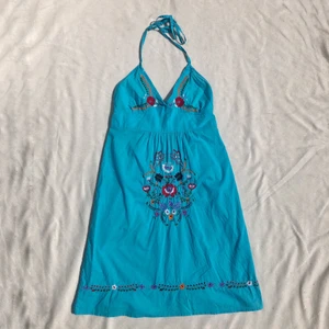 Halterneckklänning med broderi  - Jättefin turkos halterneckklänning med broderi. 90/00-tal från topshop. Passar strl 34/36. Finns en pytteliten fläck på framsidan som jag kan skicka bild på vid intresse, i övrigt fint skick, behöver bara strykas lite 💫3 för 2 på allt! 💫