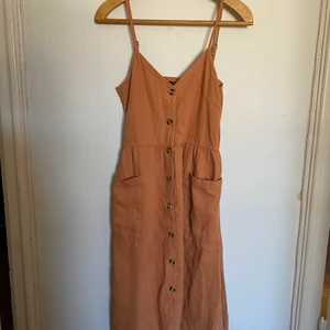 Sommarklänning , Monki , strl XS, orange - En orange/rostfärgad sommarklänning från Monki för ca 4 år sedan men som ny i skicket! 100% bomull. Vill du frakta med exempelvis PostNord blå påse istället är det självklart möjligt!