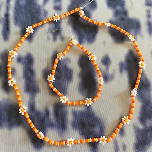 Halsband och armband i samma färger orange, vit, orangeröd och aprikosrosa. 130kr inklusive frakt