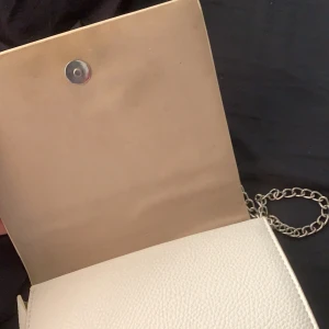 Vit axelremsväska  - Vit axelremsväska ifrån pull&bear, Själv har jag använt ett bredare axelband till väskan men den är jätte fin me de silvriga också