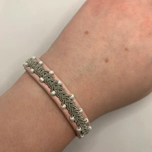Tenntrådsarmband  - Handgjort Tenntrådsarmband, rosa med vita pärlor. Materialet armbandet är gjort i är lammskinn, och flätan är gjort i tenntråd. Armbandet kan hålla i flera år. Om du har någon fråga kan du gärna skriva en kommentar eller meddela mig.