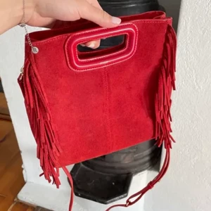 Maje väska - Säljer min asssss coola röda maje väska! Det är den stora modellen och är i bra skick utöver en missfärgning vid fransarna (bild 2). Köpt i majes butik för 2400 och använd i va 5 månader. Första bilden är lånad men be gärna om fler bilder. 