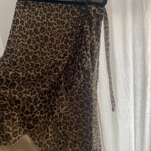 Leopard Kjol Ginatricot - Sitter snyggt, passar M, L. (Oversized i S). Finns som en slits eller va man ska kalla de, som man ser detaljerat med volang typ, knyta kan man göra med banden på sidan