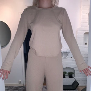 Beige ribbad tröja från Bubbleroom - Beige skön tröja ifrån Bubbleroom. Är ribbad och passar ihop med dom ribbade byxorna som också finns att köpa, köp båda för 100. Är i ett väldigt skönt fladdrigt material som passar bra nu till sommaren