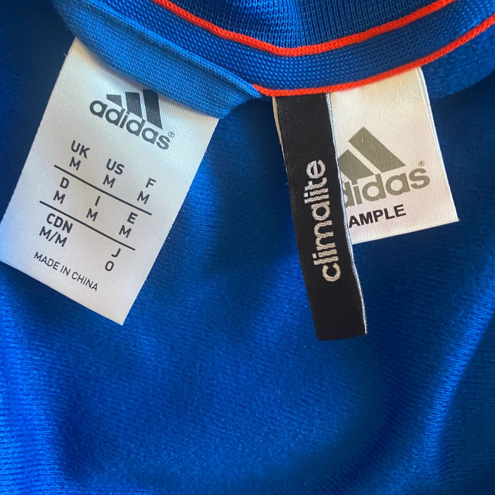 Adidas trackjacket. Köpt på second hand i californien för två år sedan. Ovanlig modell med drapering i vitt fram och oranga ränder längs sidorna . Huvtröjor & Träningströjor.