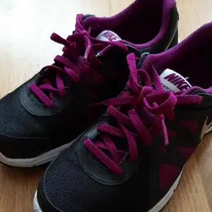 Ett par svarta och lila Nike skor i stl 37,5.