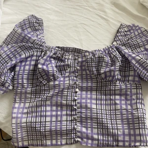 Topp i storlek M från SHEIN  - En lila rutig topp från SHEIN, använd fåtal gånger och i fint skick! Dragkedja på sidan så det är lätt att ta av och på. Fina knappar i mitten. Köparen står för frakten.