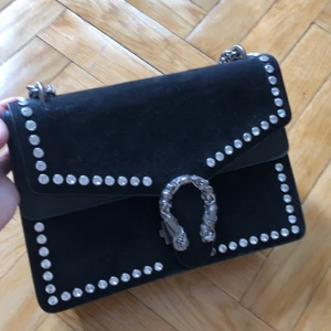 Handväska  - Aldrig använd. Svart mocka med skinndetaljer. 30x20 cm. Ficka på baksidan.5 fack inuti.