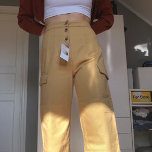 Beiga Jeans med knappar - Ett par jeans från Asos med vida ben och fina fickor på sidorna. De är aldrig använda med lapp kvar. De är i storlek 38. Säljes då det är lite för stora för mig. Skriv om fler bilder önskas eller om du har några frågor :)