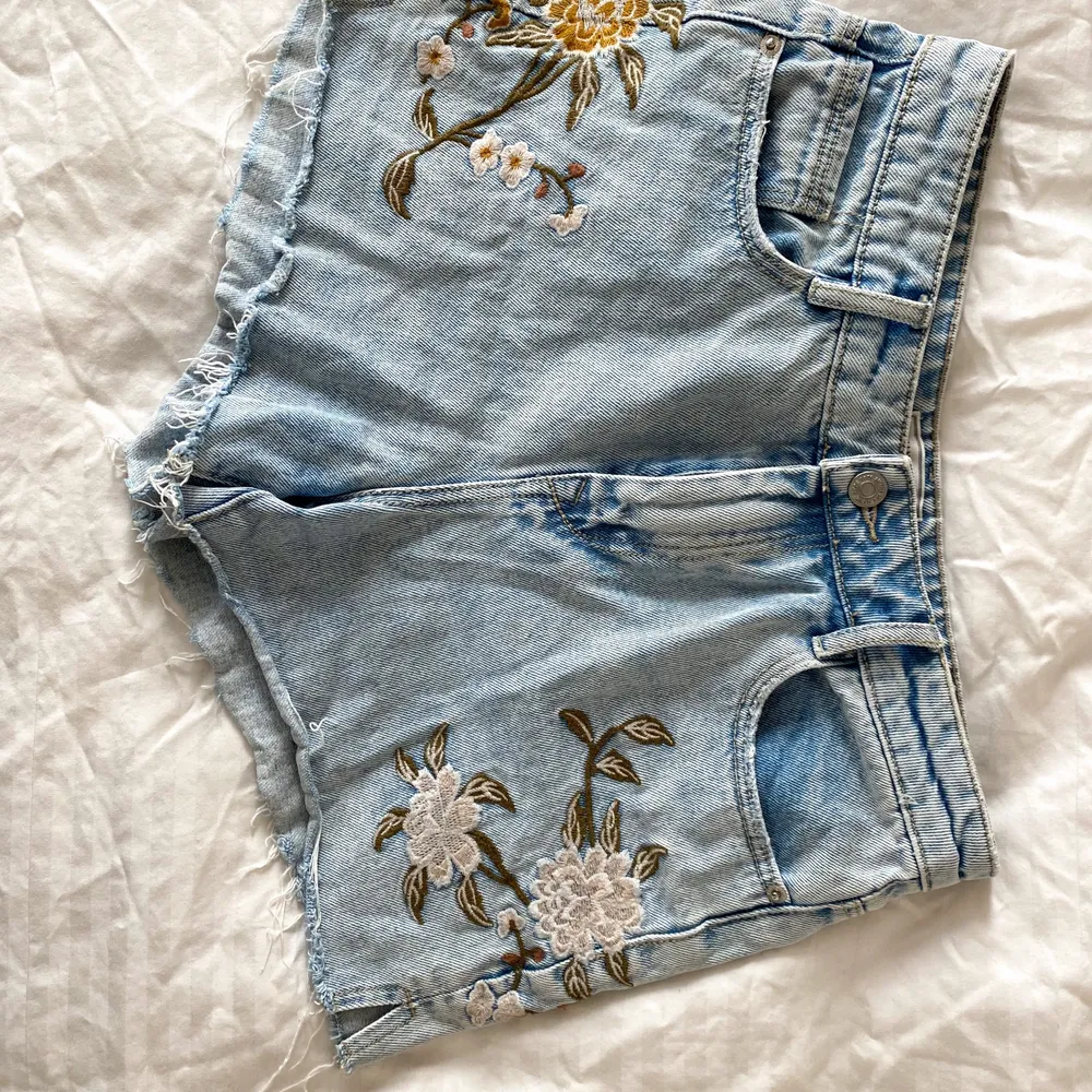 Highwaisted denim shorts with flower print, top can be bought as well!. Shorts.