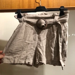 Linneshorts - Linneshorts med skärp (knäppe i trä) från New Look, storlek S. Aldrig använda.