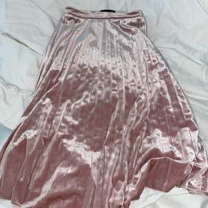 Längre ljusrosa kjol i ett slags sammet material