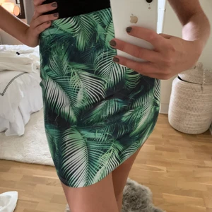 Kjol  - Tight minikjol med bladmönster, säljes i befintligt skick.