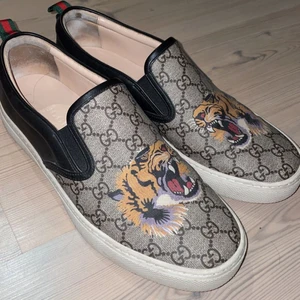 Gucci gf supreme slip-ons tiger  - Säljer mina skor då ja aldrig använder pga att dom är förstora, dom är i storlek 42 (ganska stora i storlek), väldigt bra skick (9/10), dom är beställda ifrån Gucci och de är årsmodell 2016, sugen på fler bilder då får ni säga till. 1800+ frakt 