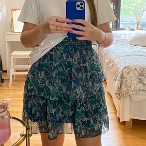 Volangkjol - Kjol. Plagget är från Saint Tropez. I oanvänt skick. Strl S. Med brett resårband i midjan som man kan vika hur man vill för att få kjolen kortare. Köpt för 399kr. 