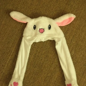 Söt kaninhatt  - En gullig vit fluffig kaninhatt och när man klämmer på tassarna så åker äronen upp💕! Den är använd ett par gånger men är fortfarande i bra skick!:) frakt kostnad är varierande så fråga om du vill veta 
