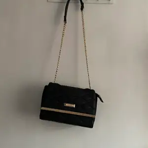 Em svart handväska med kedjeband