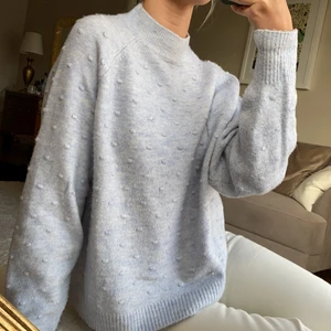 Babyblå stickad tröja - Stickad tröja i en fin ljusblå färg. Stickade små prickar över hela tröjan och ribbstickad krage och ärmslut.