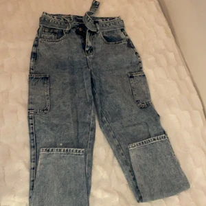 Blå momjeans med detaljer - Ett par blå momjeans jeans detaljer som på det ihåliga bältet och fickor på sidorna. Väldigt skön och håller bra. Har haft de ett tag men bara använt 2 gånger! 
