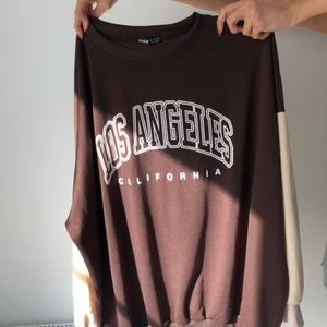 Sweater - Brun sweatshirt men beiga armar med tryck på framsidan, storlek M, väldigt oversize och stor i storleken