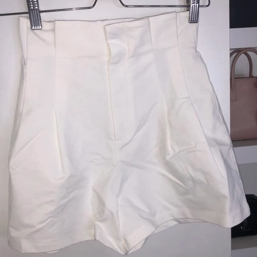 Vita höga shorts med ”volang-kant upptill”, från H&M. Storlek XS/32. Gott skick. Lite balongformade. Ser dyra ut.. Shorts.