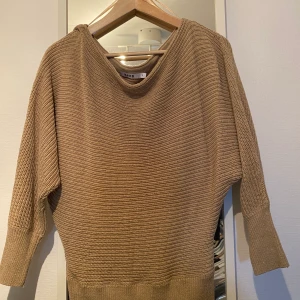 Beige stickad tröja från NA-KD - Beige stickad tröja från nakd i storlek S. Ganska använd men i bra skick! Det stramar åt vid handlederna och vid midjan