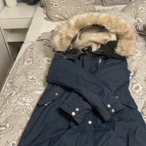 Vinterjacka  - Jackan är lång och varm. Inuti finns det fake päls vid luvan och lite ner till ryggen.                                                Ny pris: 2000kr. Jag säljer jackan för 600kr                               