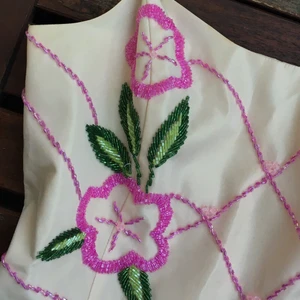 ? -  linne med pärlbroderi på som bildar blommor och linjer runt toppen. strlk 40 (jag som använt toppen har xs) 