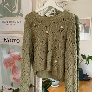 Stickad tröja från ASOS med solrosor. L - Säljer en grön stickad tröja från ASOS med solrosor på. Storlek L och är true-to-size. Helt oanvänd 