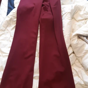 Vinröda Långbyxor kostymbyxor - Vinröda kostymbyxor med dragkedja i sidan. Vida och stretchiga, supersnygga 💯 Endast provade 😅 