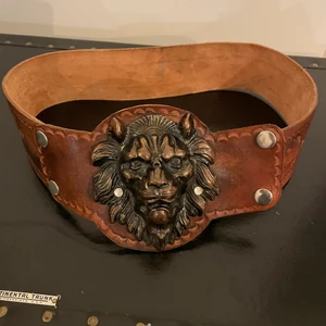 Snyggt brunt vintageskärp - Snyggt vintageskärp Färg: Brunt med lejondetalj Skick: Färgskiftningar i skinnet. Mått: ungefär 85 cm