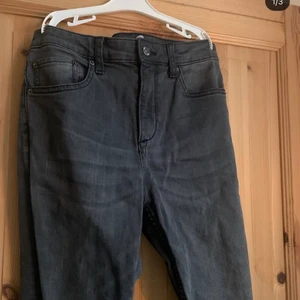 Mörkgråa jeans med hål - Dessa jeansen ser ganska små ut men är väldigt stretchiga. Jag har aldrig använt dom utan det är ett år jag fått men kvalitén är ändå ganska bra (finns inga skador på plagget).🤍 Byxorna har hål vid knäna ish som ska vara där och byxorna har även trådar som hänger lite vid nederdelen/slutet av byxorna som även dom ska vara där🤍