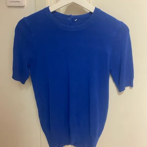 Blå stickad tröja - Säljer denna jättefina blåa stickade tröjan. Men guldiga knappar där bak.