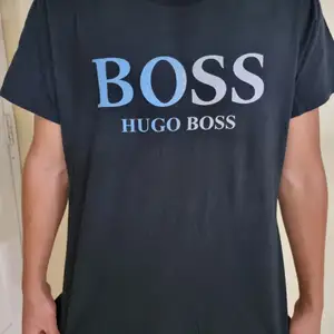 Ytterligare en oanvänd Hugo Boss t-shirt med centrerad text och svartblå bakgrund. Simpel design fu kar med det mästa. Framhäver dina armar och är väldigt behaglig att ha på sig.       (!Tar häldst swish!)