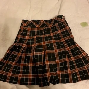 Veckad kjol - Superfin Svart röd veckad kjol. Knappt använd från H&M. I storlek 34 och är LITE stretchig. Säljer då den inte kommer till användning🥰