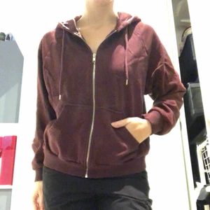 Vinröd hoodie - En enkel, skön och mysig hoodie med luva och dragkedja. Den är vinröd i färgen och är nästan som ny trots välanvänd. Katt finns i hemmet!